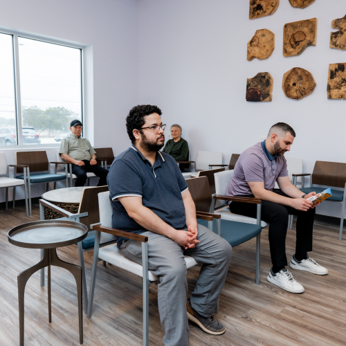 Adult patients in waiting room at ApexMed Primary Care Clinic